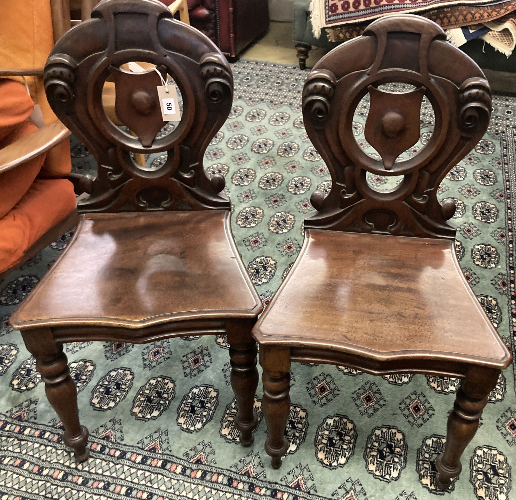 A pair of Victorian mahogany hall chairs